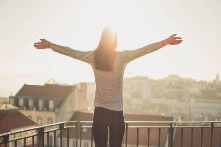 woman standing on balcony relaxing